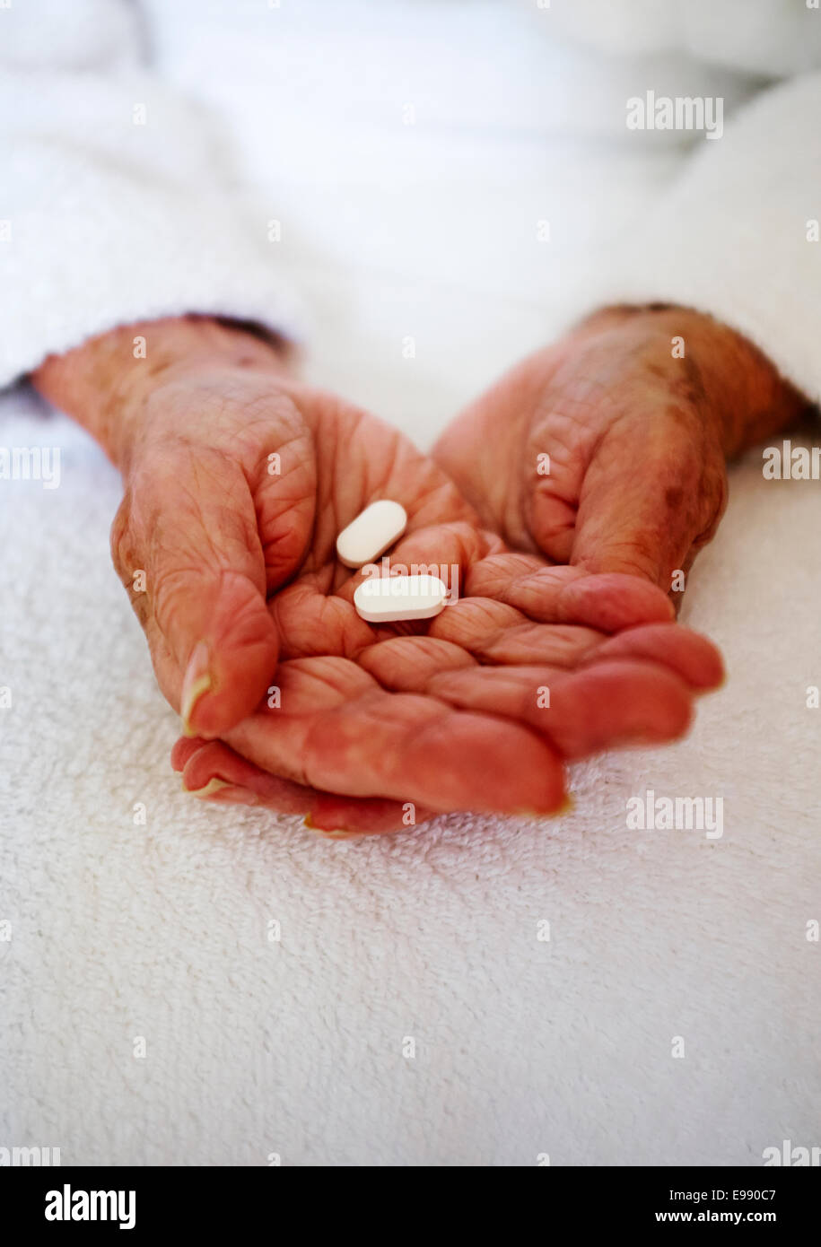 Senior person's hands holding medication - nursing home healthcare. Stock Photo