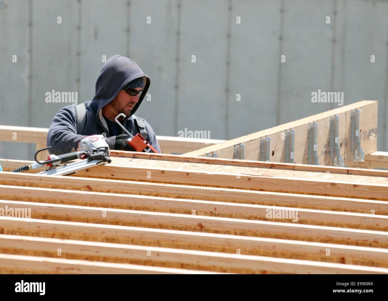 A construction worker installing silent floor joists in new construction Stock Photo