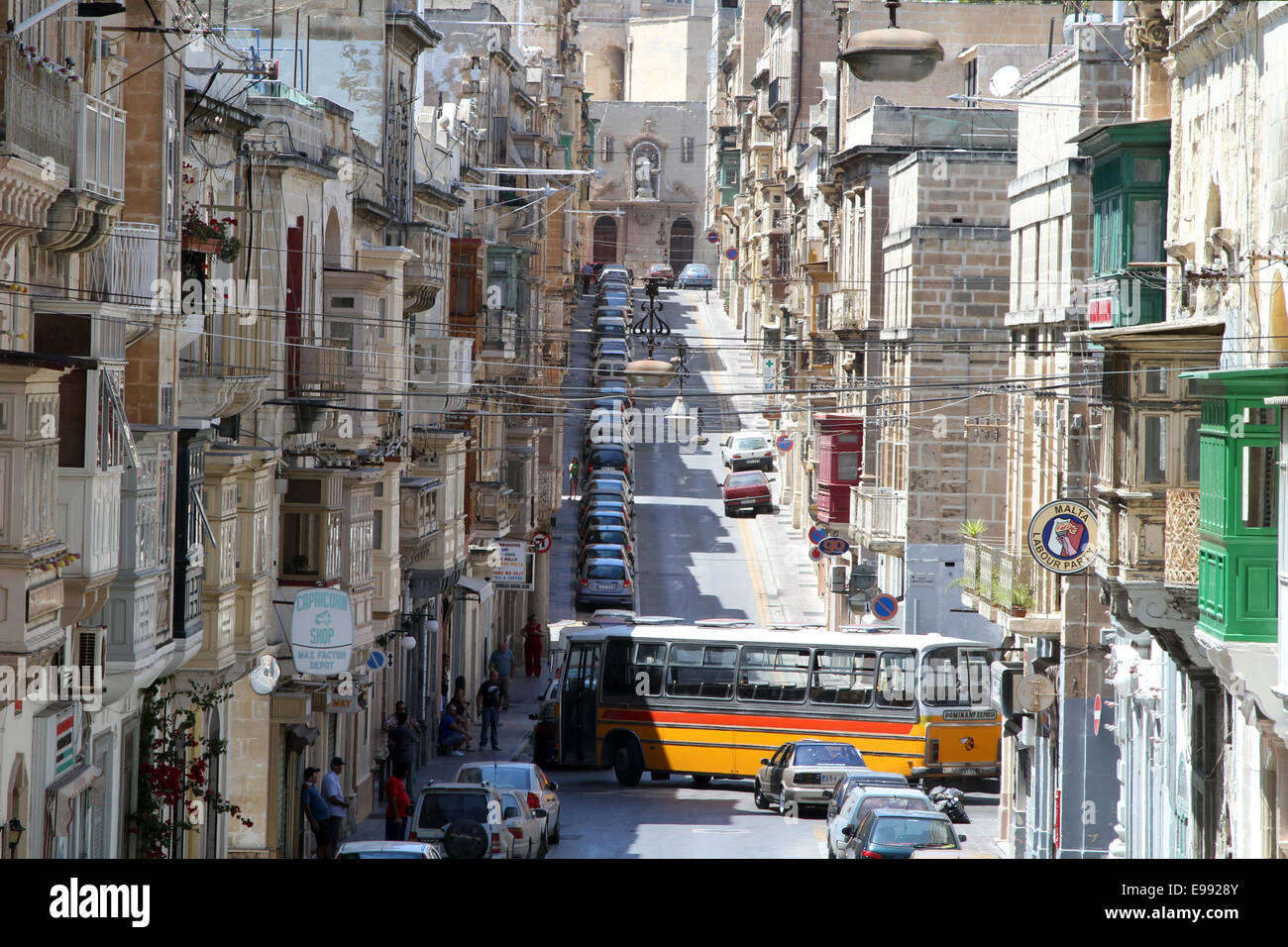 A bus tries to navigate through the narrow gaps on Triq il-Vitoria, on the Seglea peninsula in Valletta, Malta Stock Photo