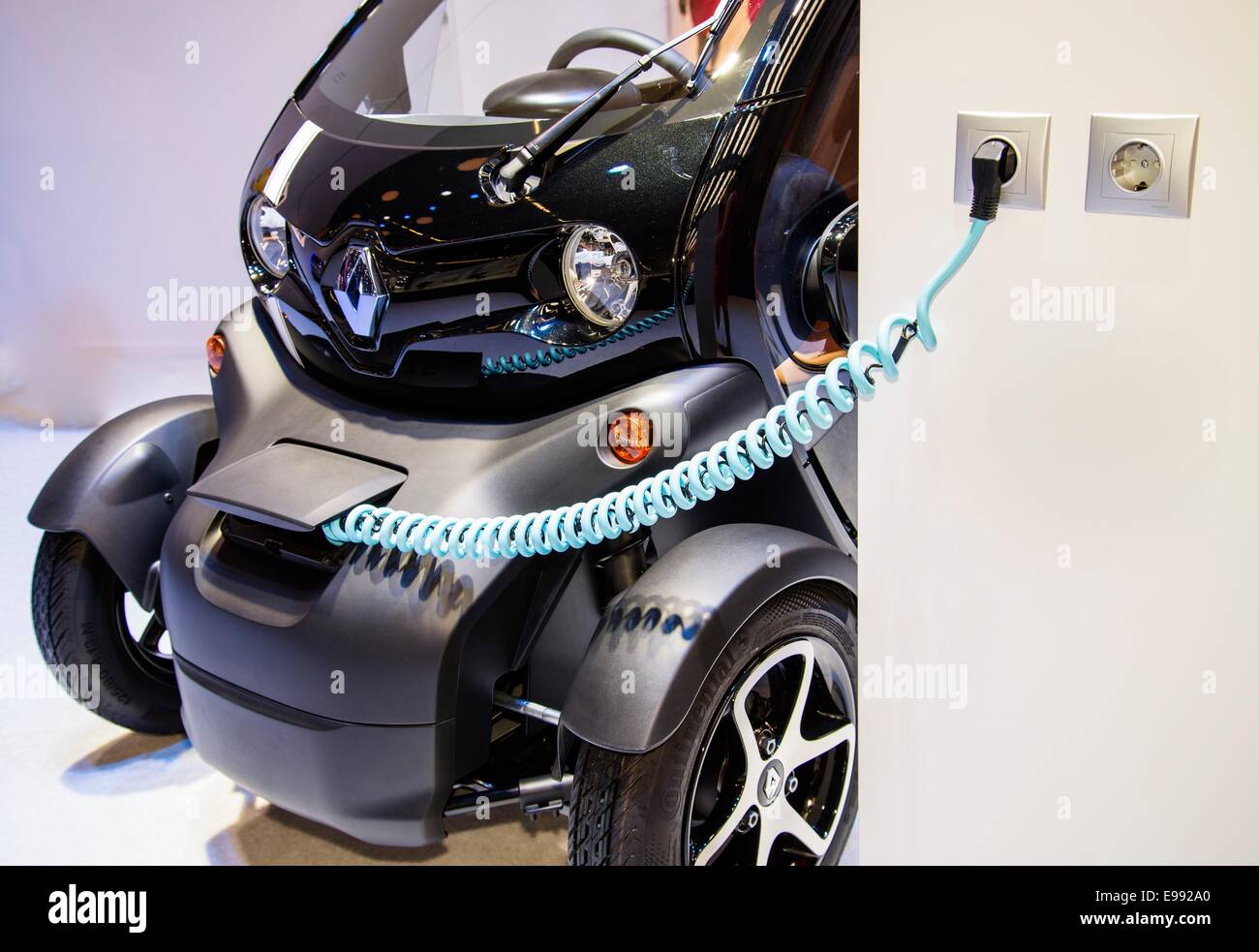 An Electric car of the brand Renault Twizy is charged at a charging station. Digital Composite (DC) Stock Photo