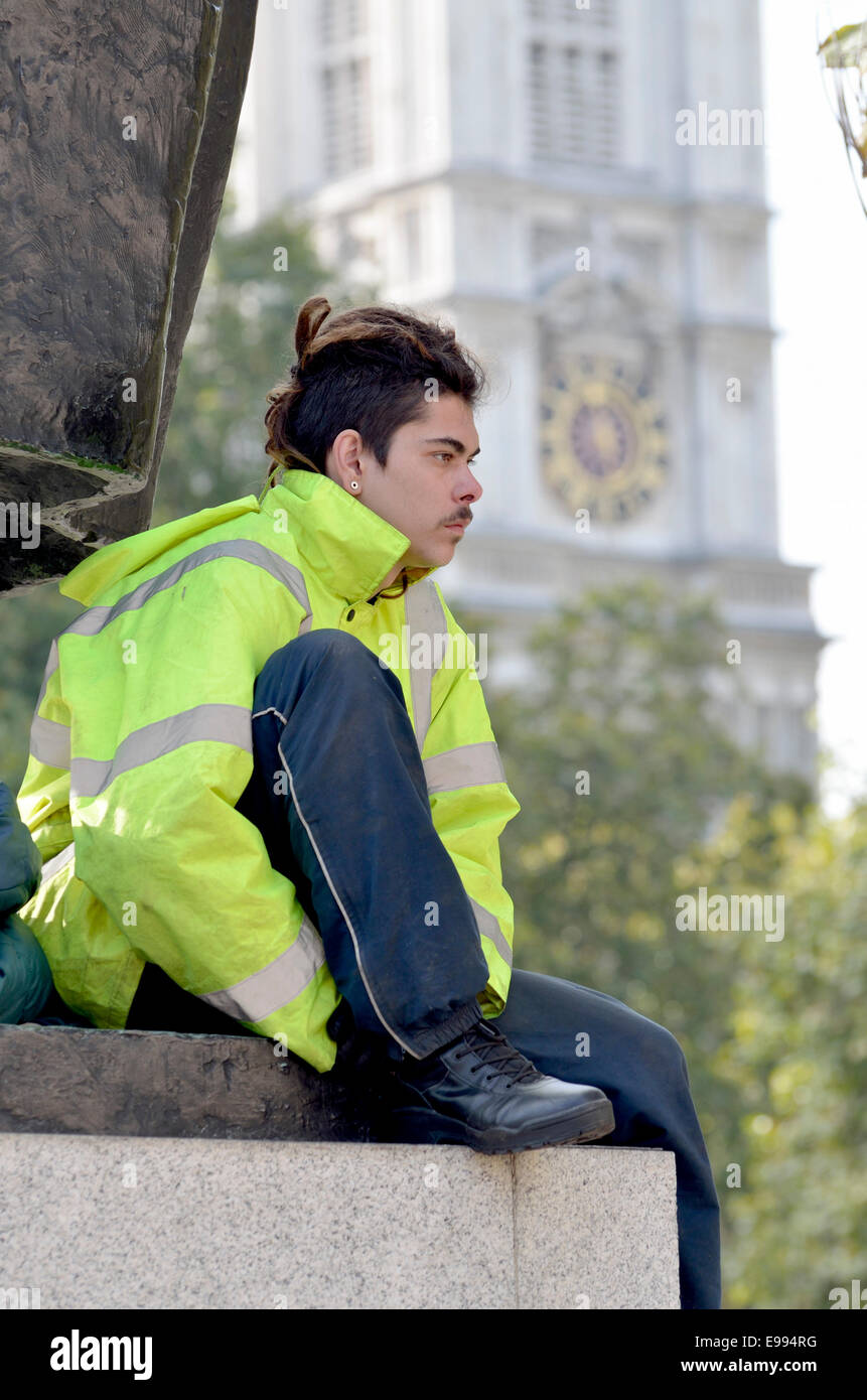 London, UK. 22nd October, 2014. Occupy London protester 'Plinth Guy' remains on the plinth of the Winston Churchill statue in Parliament Square -  police arrest a man for throwing  food to him. Stock Photo