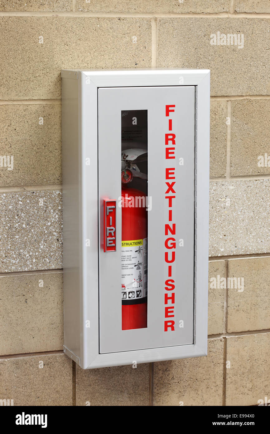A fire extinguisher in a wall mounted storage box Stock Photo