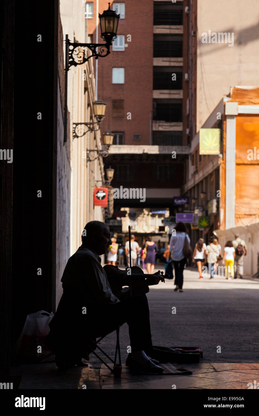 Old man fiddle playing and busking in a side street in Valencia, Spain