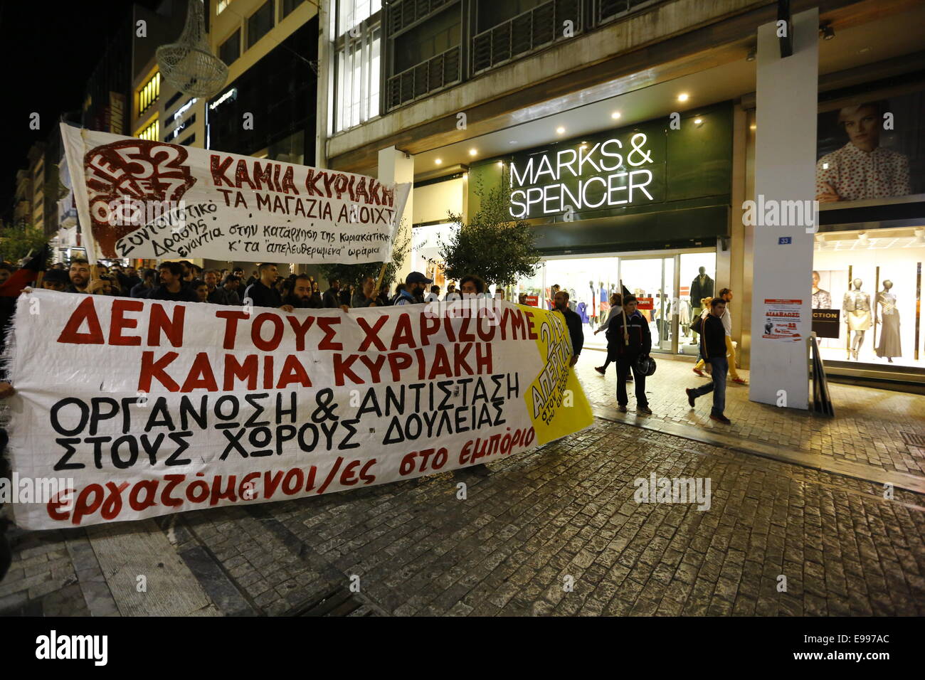 Athens, Greece. 22nd October 2014. The protest march against the opening of shops on Sundays passes by a store of the British chain Marks & Spencer. Shop workers and owners united in a protest against the opening of shops in Greece on Sunday. The law that allows shops to open on Sundays was brought in this summer and is supposed to increase the revenue of shops and create 300,000 new jobs. Credit:  Michael Debets/Alamy Live News Stock Photo