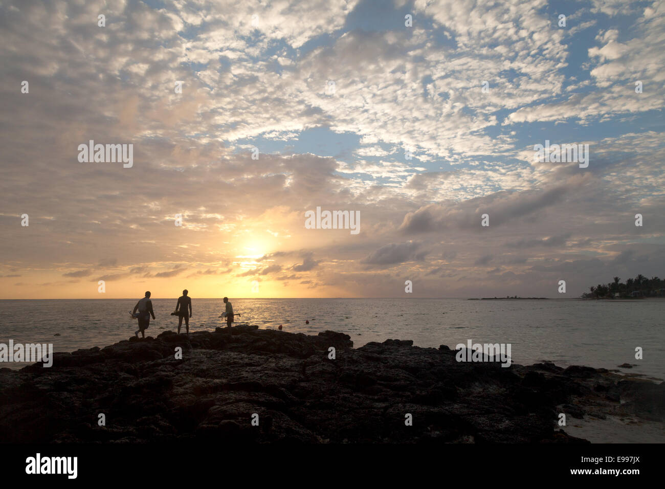 Local mauritian spear fishermen going hunting for fish and octopus at sunrise, Belle Mare Beach Mauritius Stock Photo