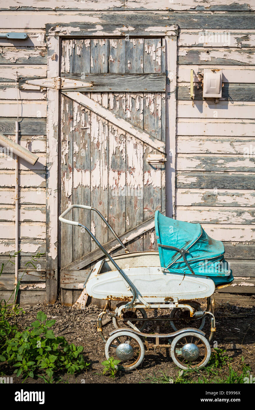 An old grainery door and baby carriage on the Froese farm near Winkler, Manitoba, Canada. Stock Photo
