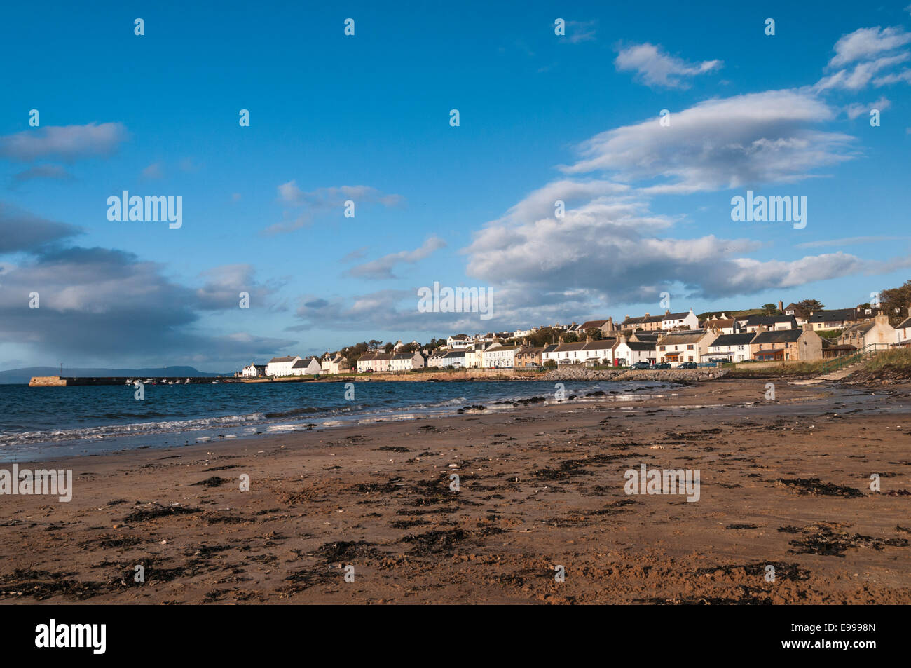 A photograph of Portmahomack, Easter Ross, Scotland, taken along the beach showing the town and harbour Stock Photo