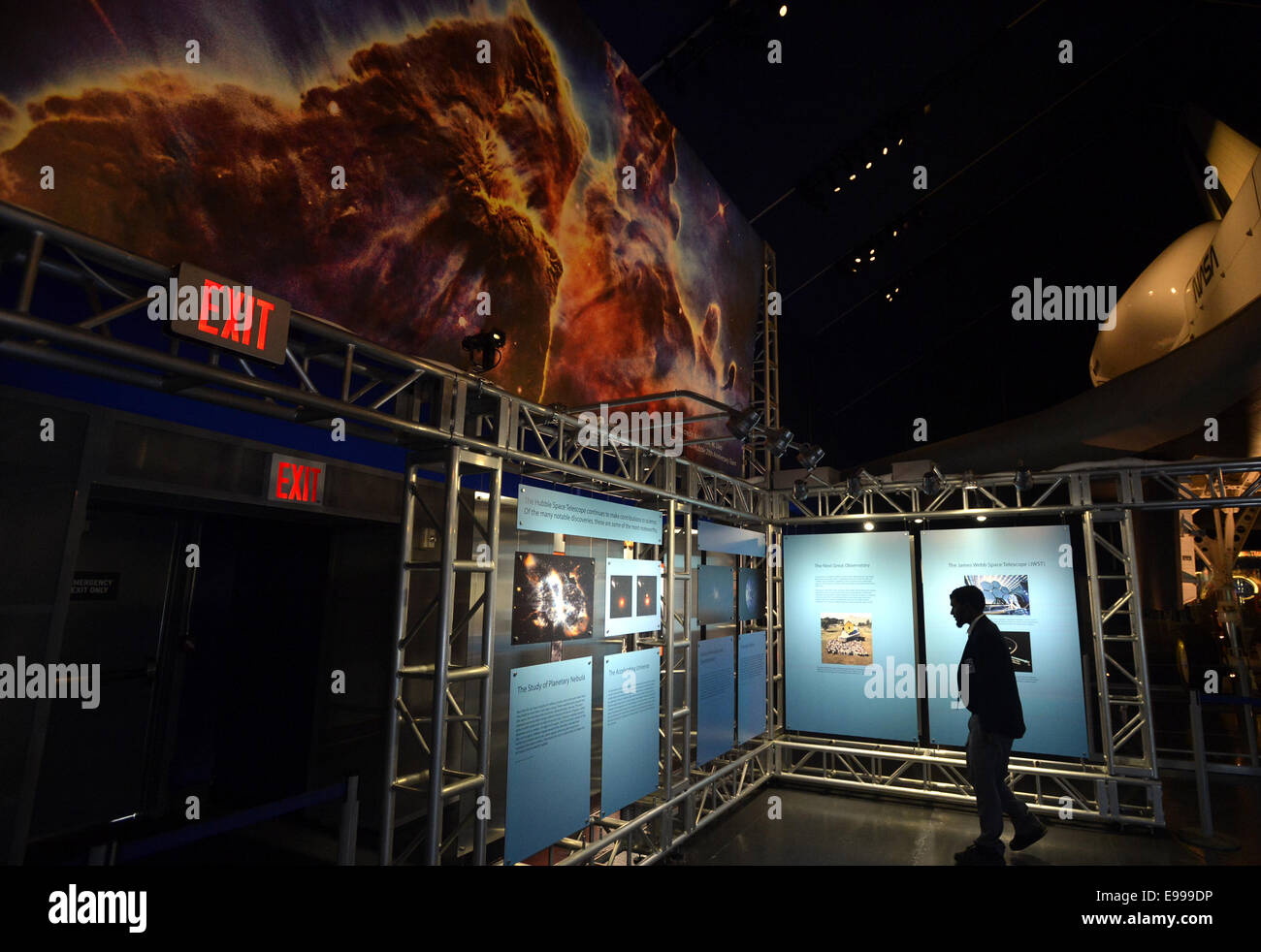 New York, USA. 22nd Oct, 2014. A reporter attends the press preview of a new exhibit named 'HUBBLE@25', which is to celebrate the 25th anniversary of NASA's launch of the Hubble Space Telescope, at the Intrepid Sea, Air & Space Museum in New York City, the United States, Oct. 22, 2014. Through the images produced by Hubble, tools used in space to repair the telescope, and interactive guests' experiences, the exhibit will open to the public on Thursday and tell the story of Hubble's 25-year history. Credit:  Wang Lei/Xinhua/Alamy Live News Stock Photo