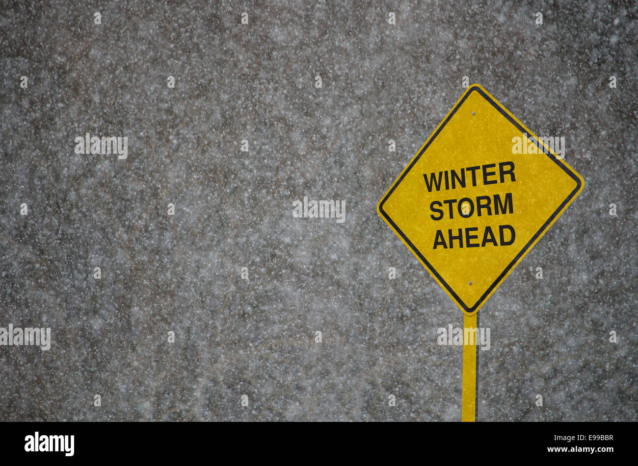 Winter Storm Road Sign: A Caution Sign in front of storm clouds warning of 'Winter Storm Warning.' Stock Photo