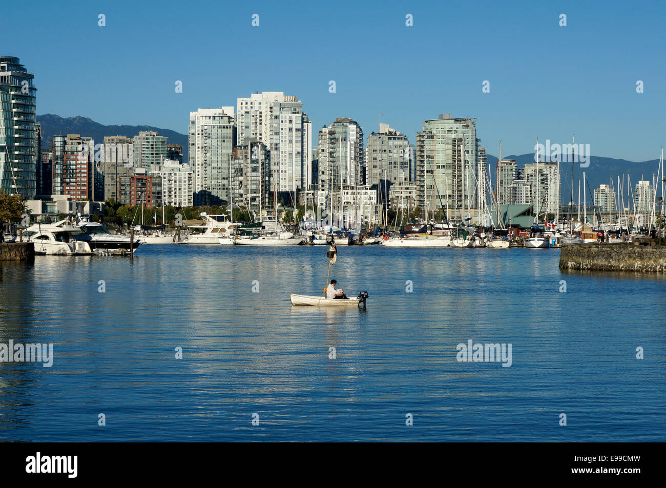 Man sitting alone in a small sailboat, False Creek, Vancouver, British Columbia, Canada Stock Photo