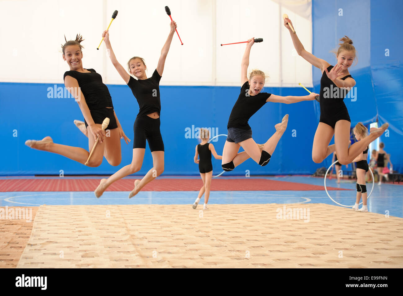 Girls with Indian clubs during high jump Stock Photo