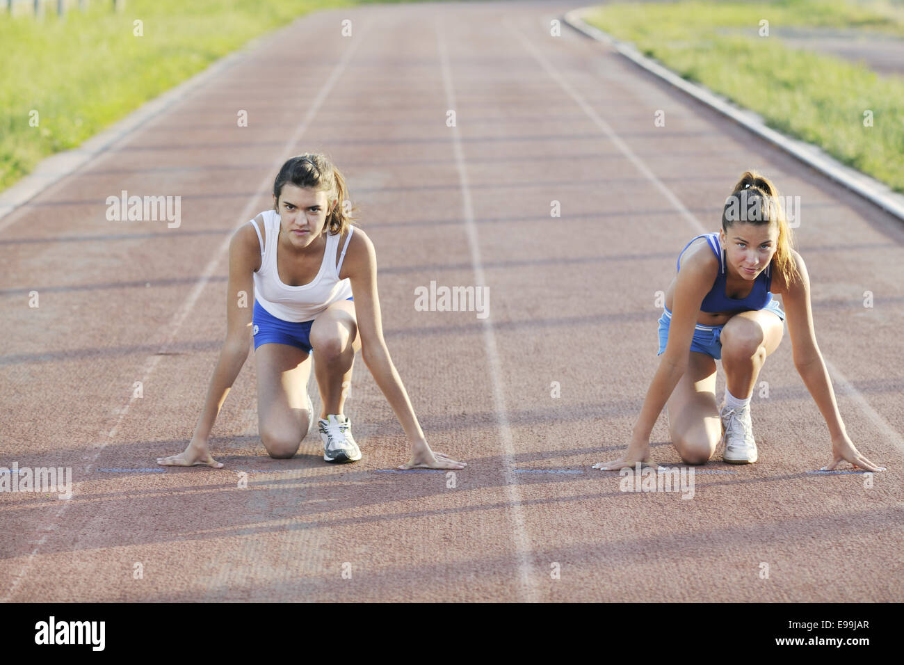 two girls running on athletic race track Stock Photo - Alamy