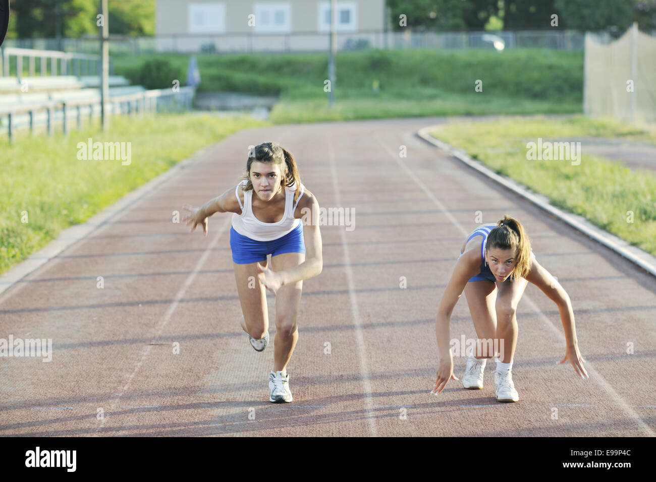 two girls running on athletic race track Stock Photo Alamy