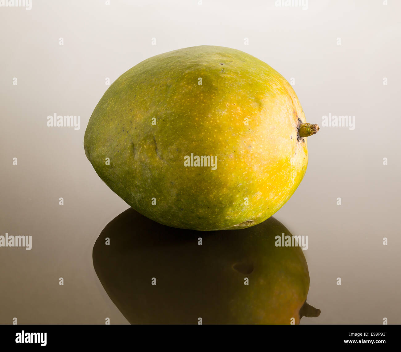 Green mango on mirror like surface Stock Photo