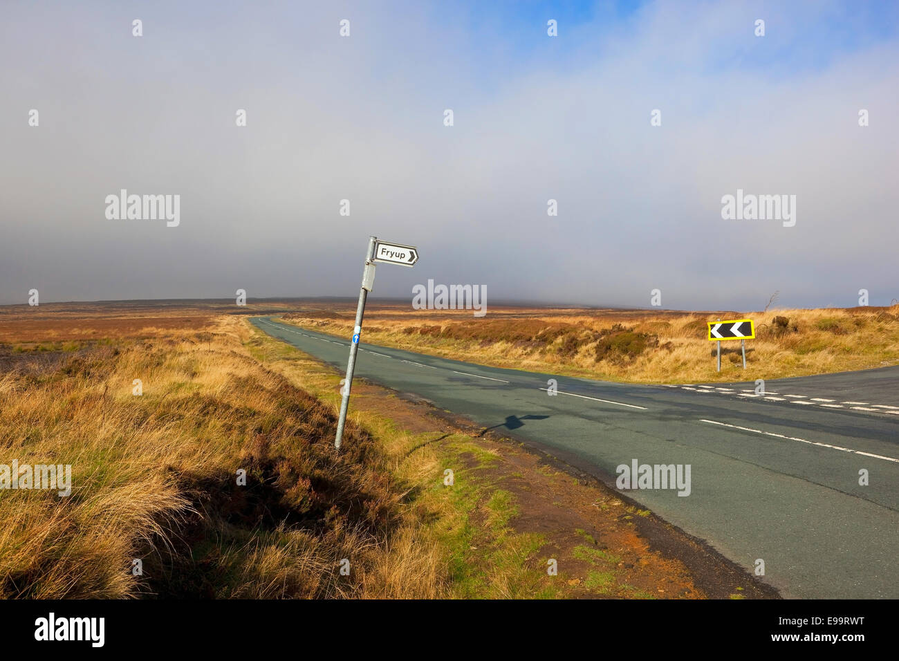 A sign post pointing the way to Fryup by a highway in a misty Autumn moorland landscape on the North York moors Stock Photo