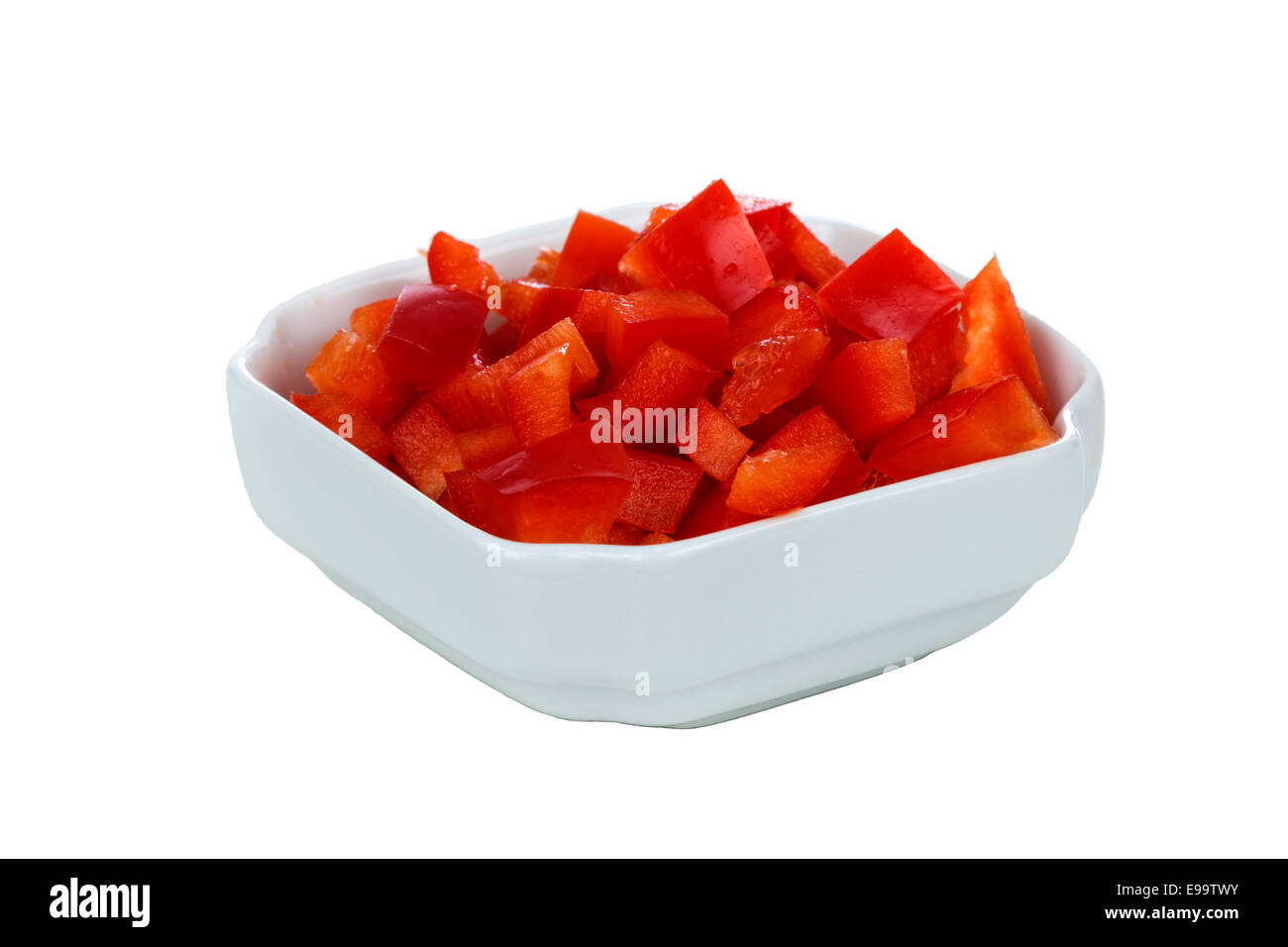 Chopped red pepper in white bowl over white background Stock Photo