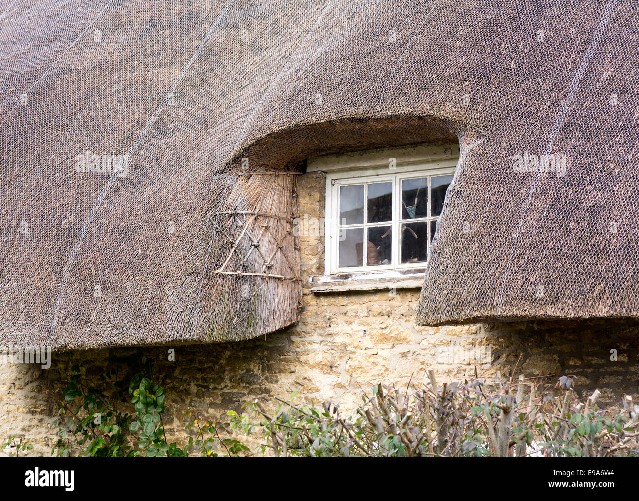 Small wooden window under thatched roof Stock Photo