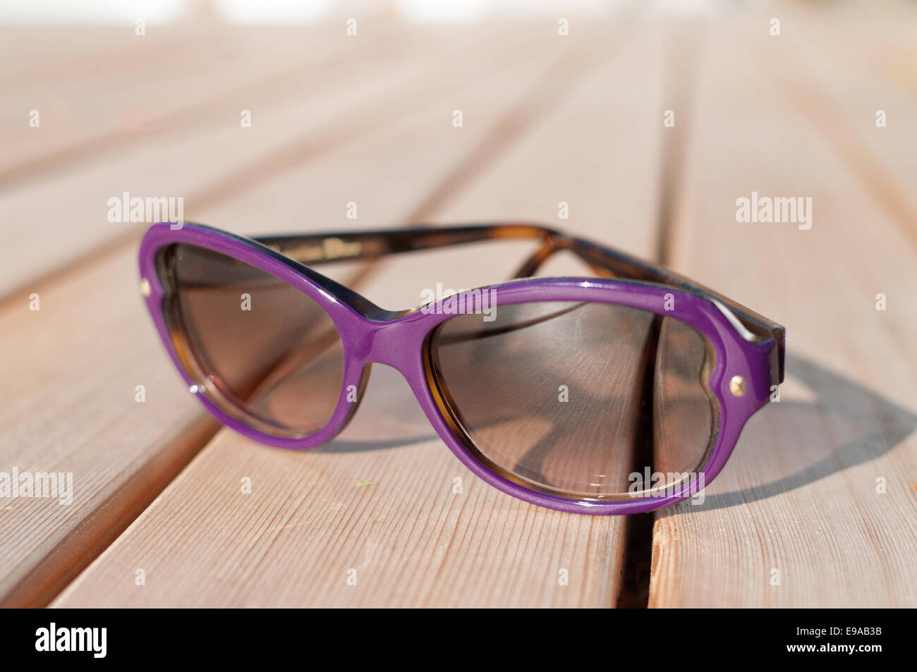 Purple sunglasses on cedar deck Stock Photo