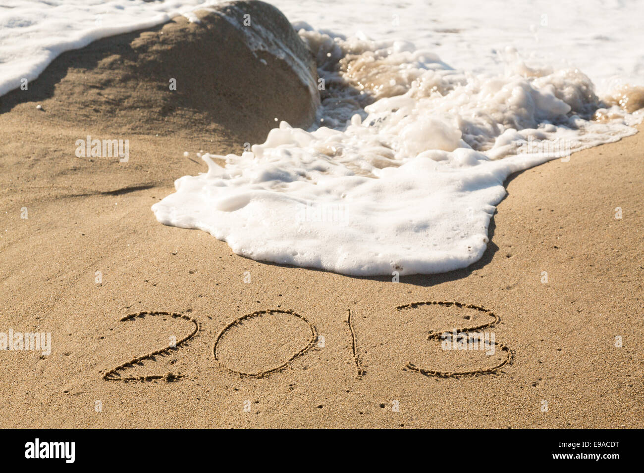 2013 in sand being covered by sea waves Stock Photo