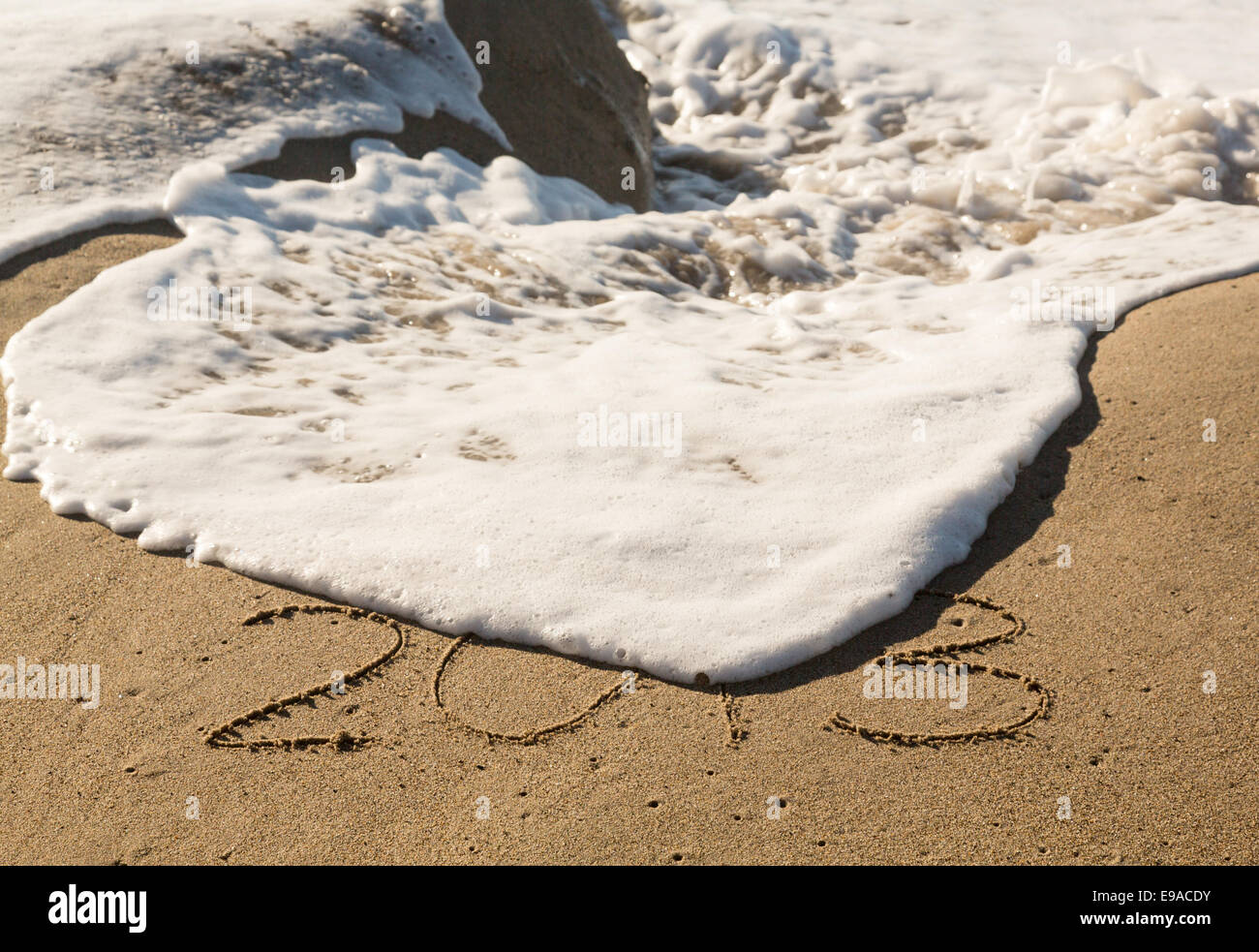 2013 in sand being covered by sea waves Stock Photo