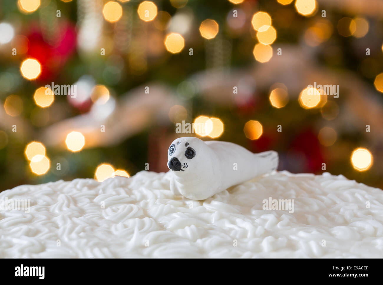 Icing on Christmas cake with tree lights Stock Photo