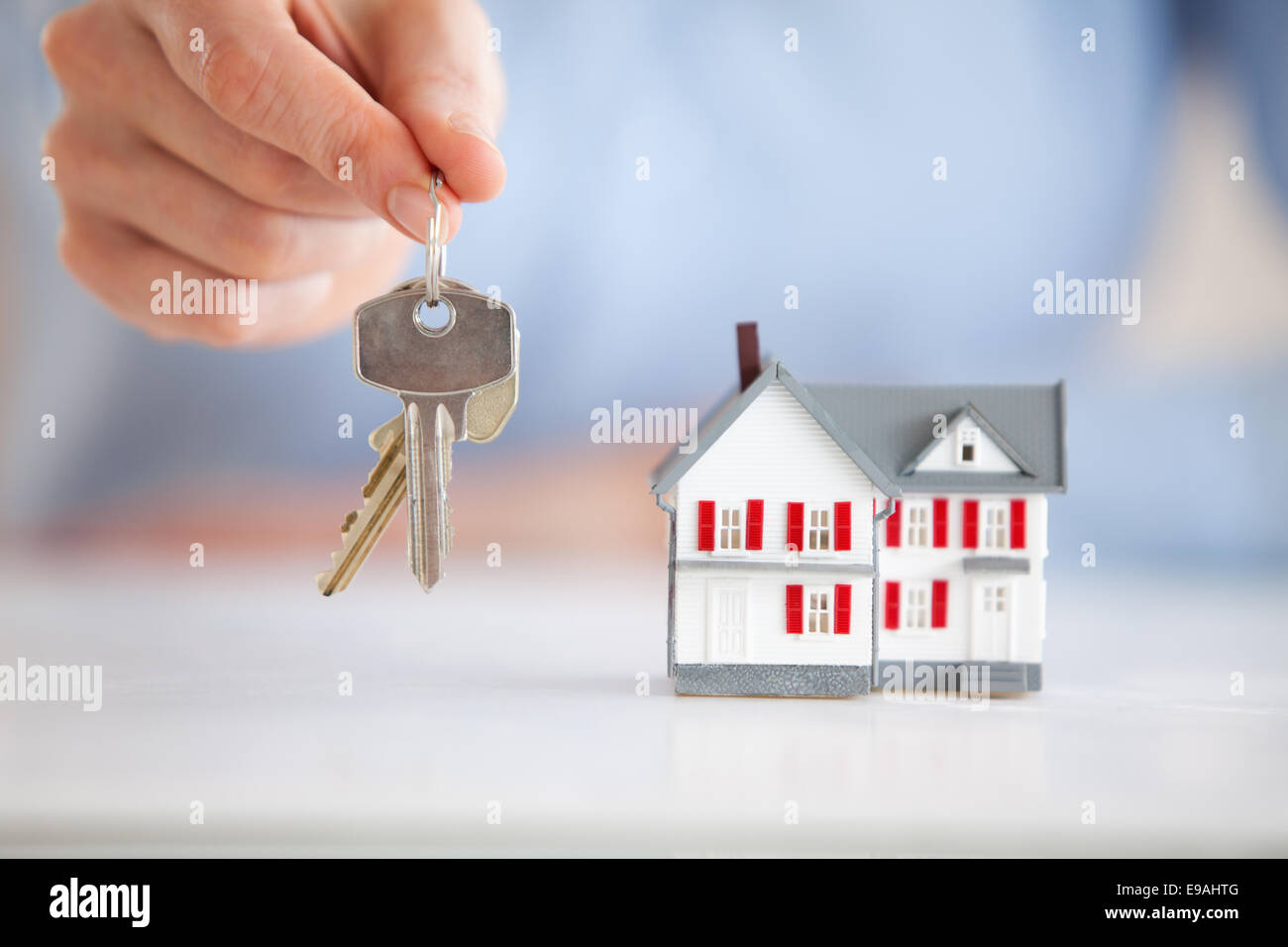 Woman holding keys next to a model house Stock Photo - Alamy