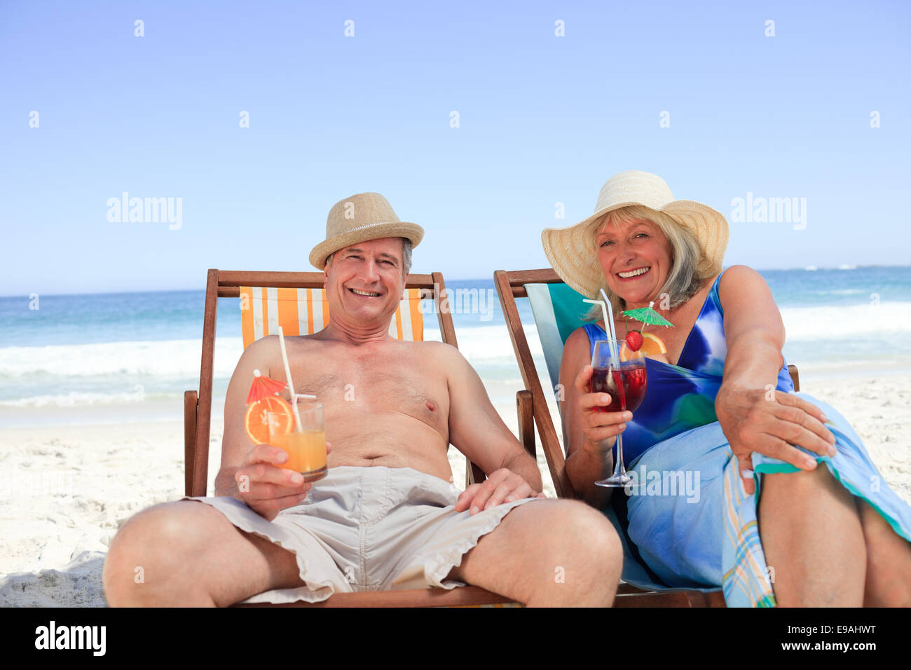 Mature couple sitting on deck chairs Stock Photo - Alamy