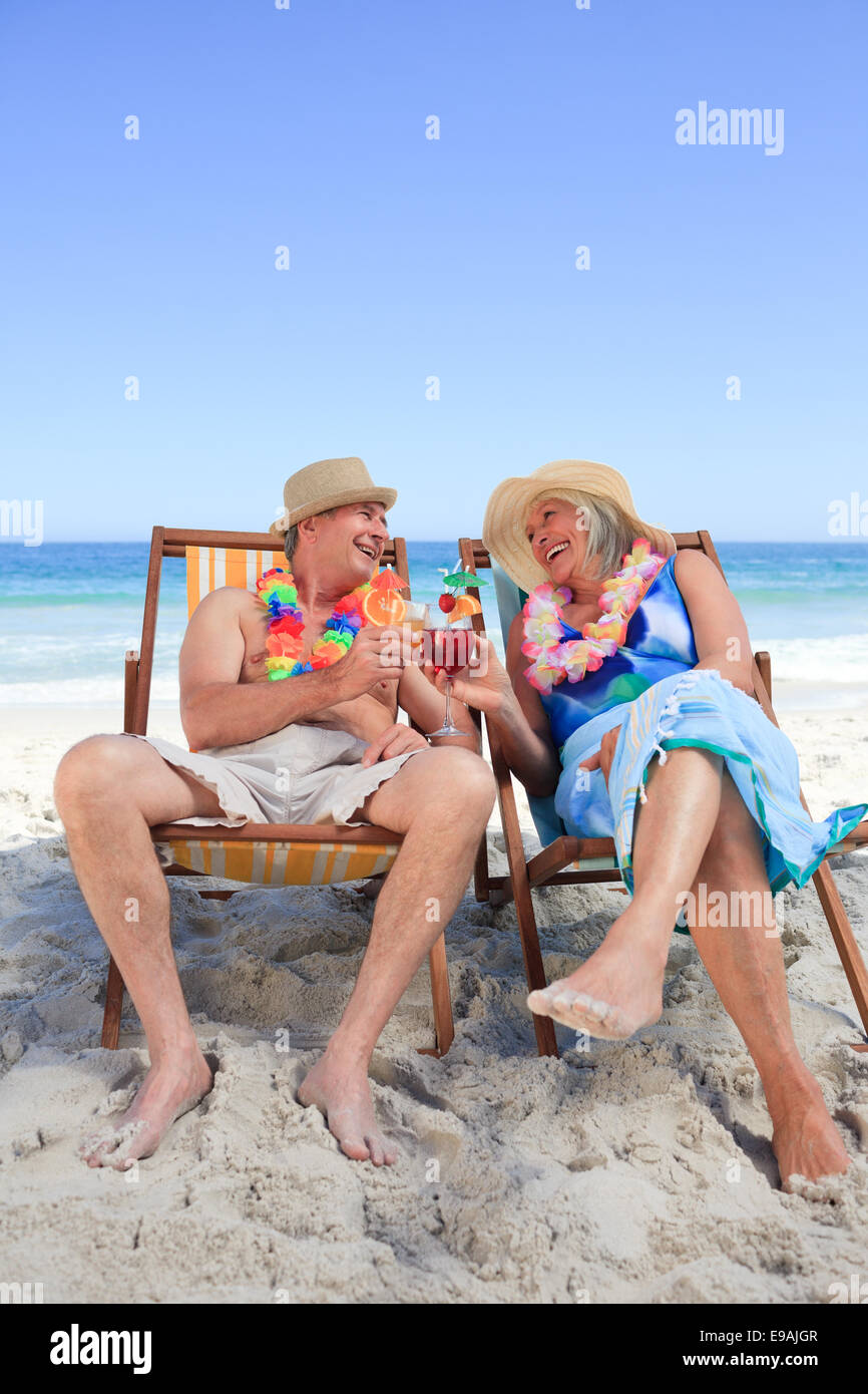 Mature couple sitting on deck chairs Stock Photo - Alamy