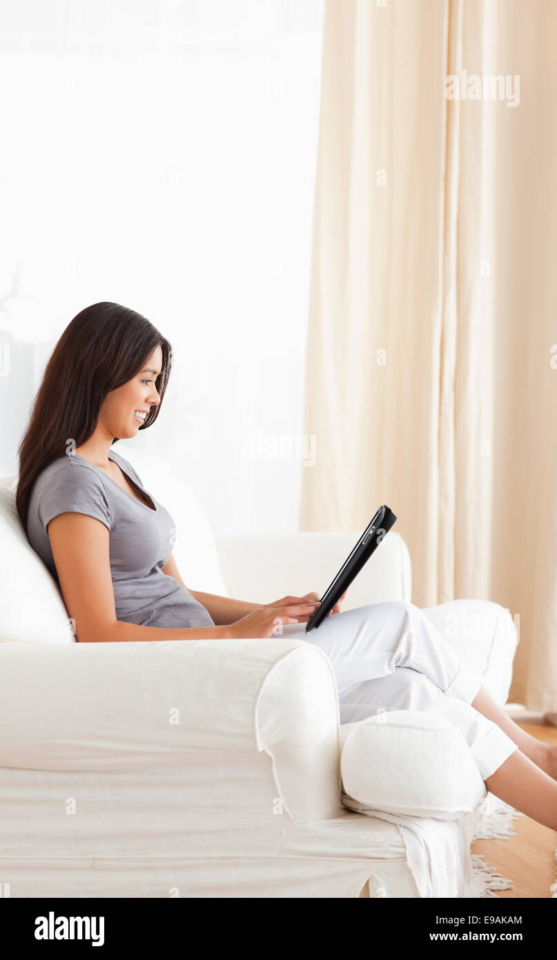 smiling woman sitting on sofa with tablet Stock Photo - Alamy