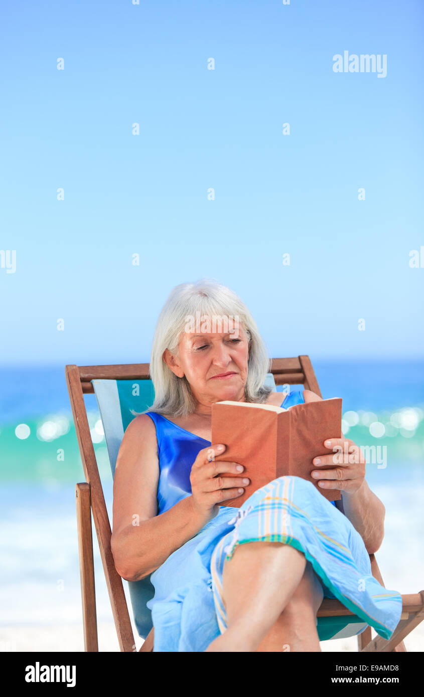 Senior woman reading a book on the beach Stock Photo - Alamy