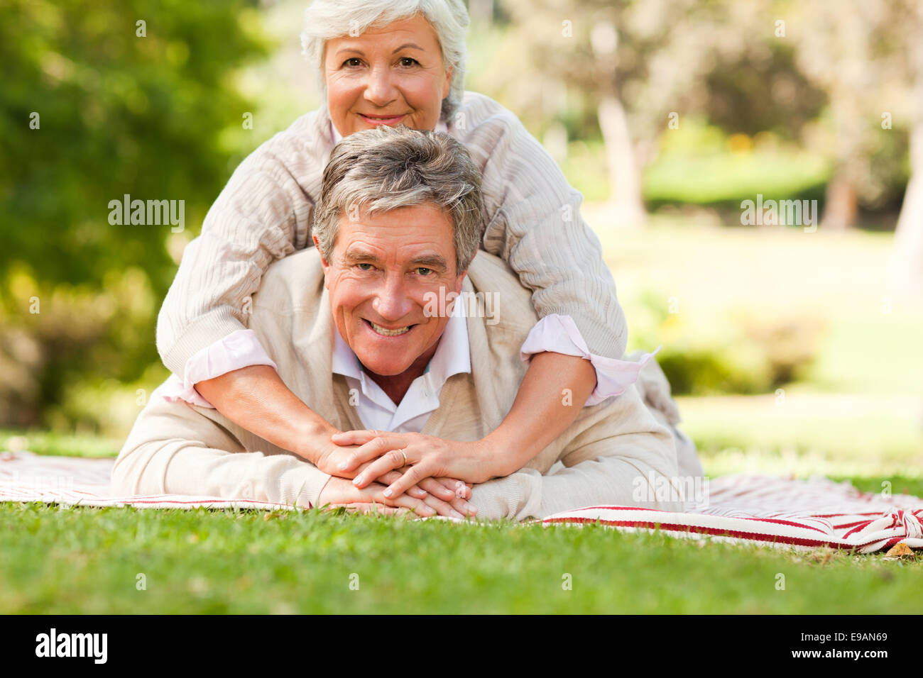 Mature couple lying down in the park Stock Photo - Alamy