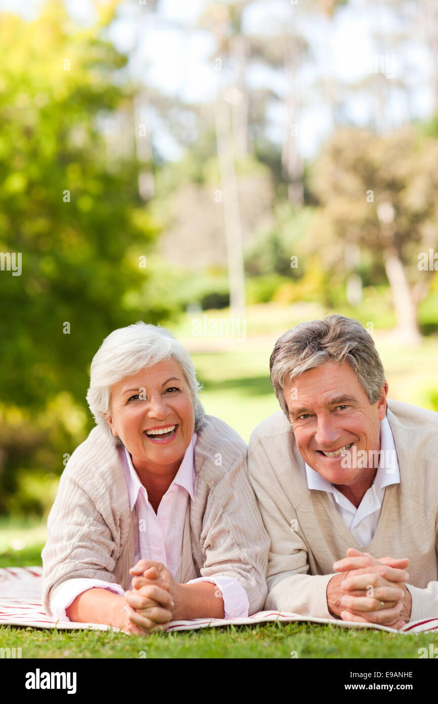 Mature couple lying down in the park Stock Photo - Alamy