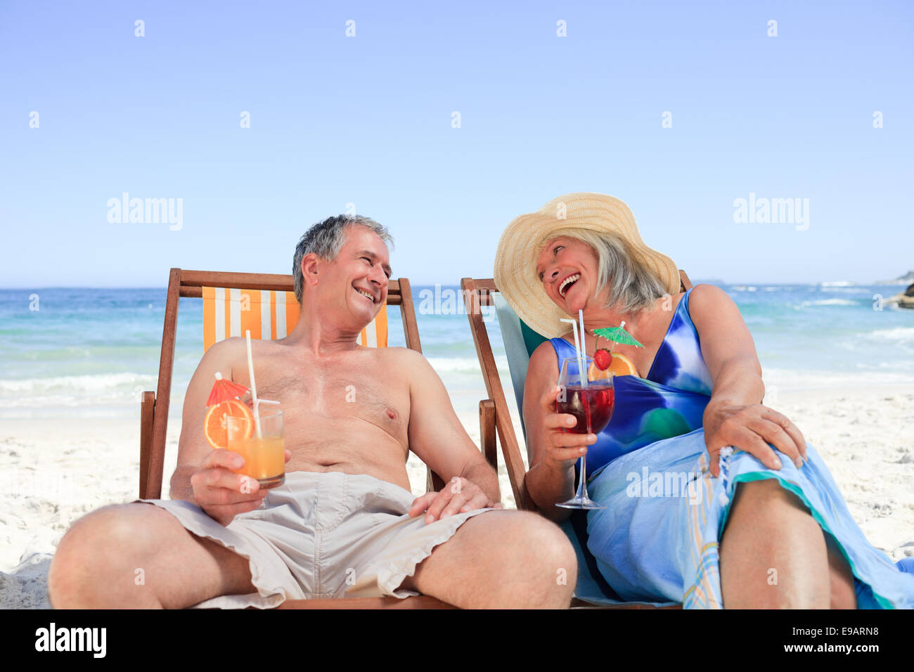Senior couple sitting on deck chairs Stock Photo - Alamy