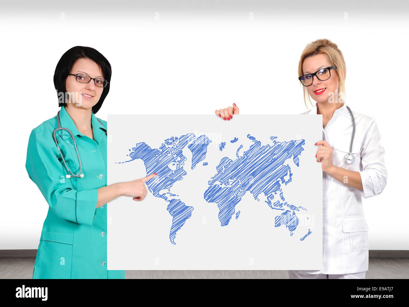 two female doctor holding poster with world map Stock Photo
