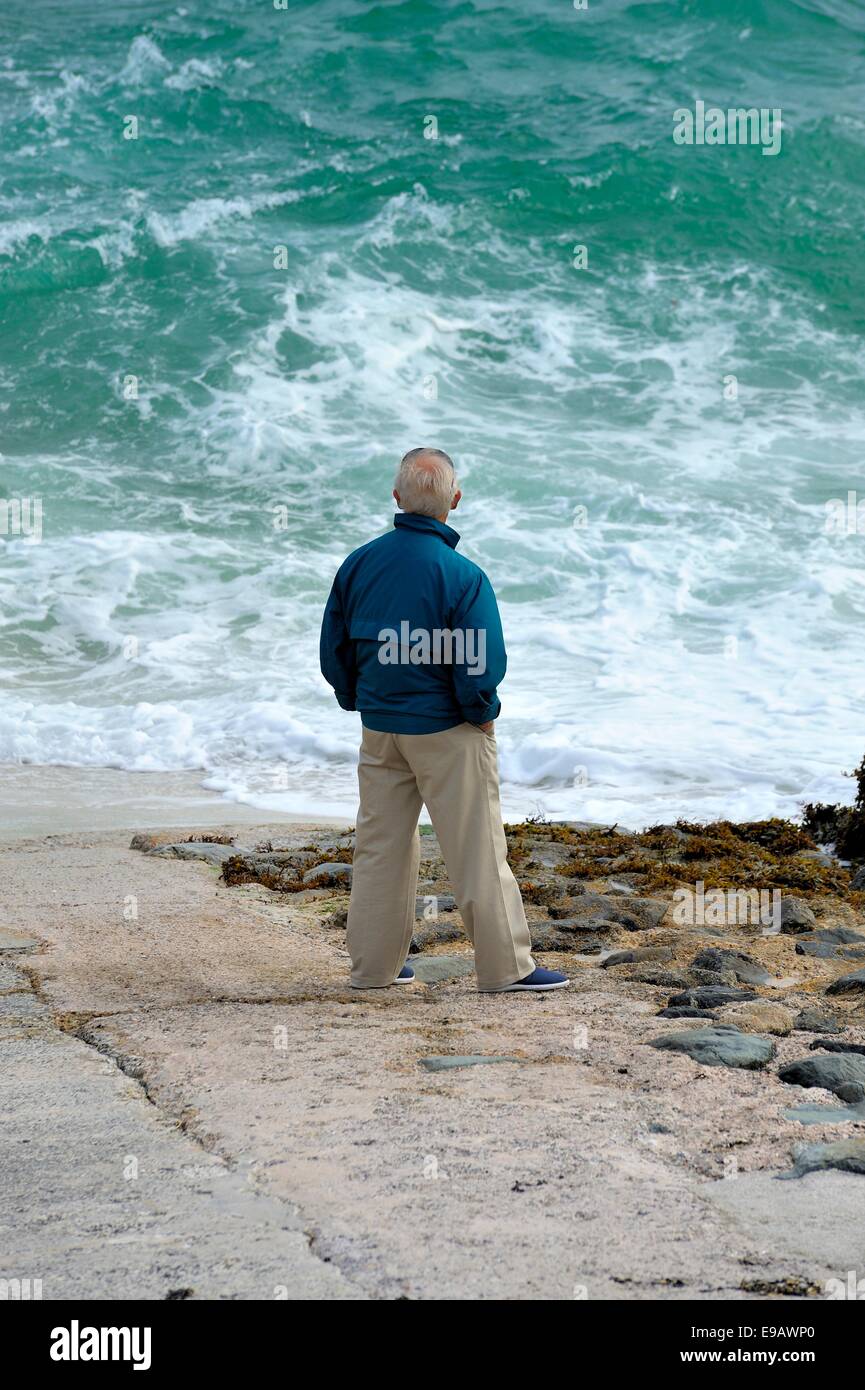 A senior man looking out into a choppy sea St Ives Cornwall England uk Stock Photo