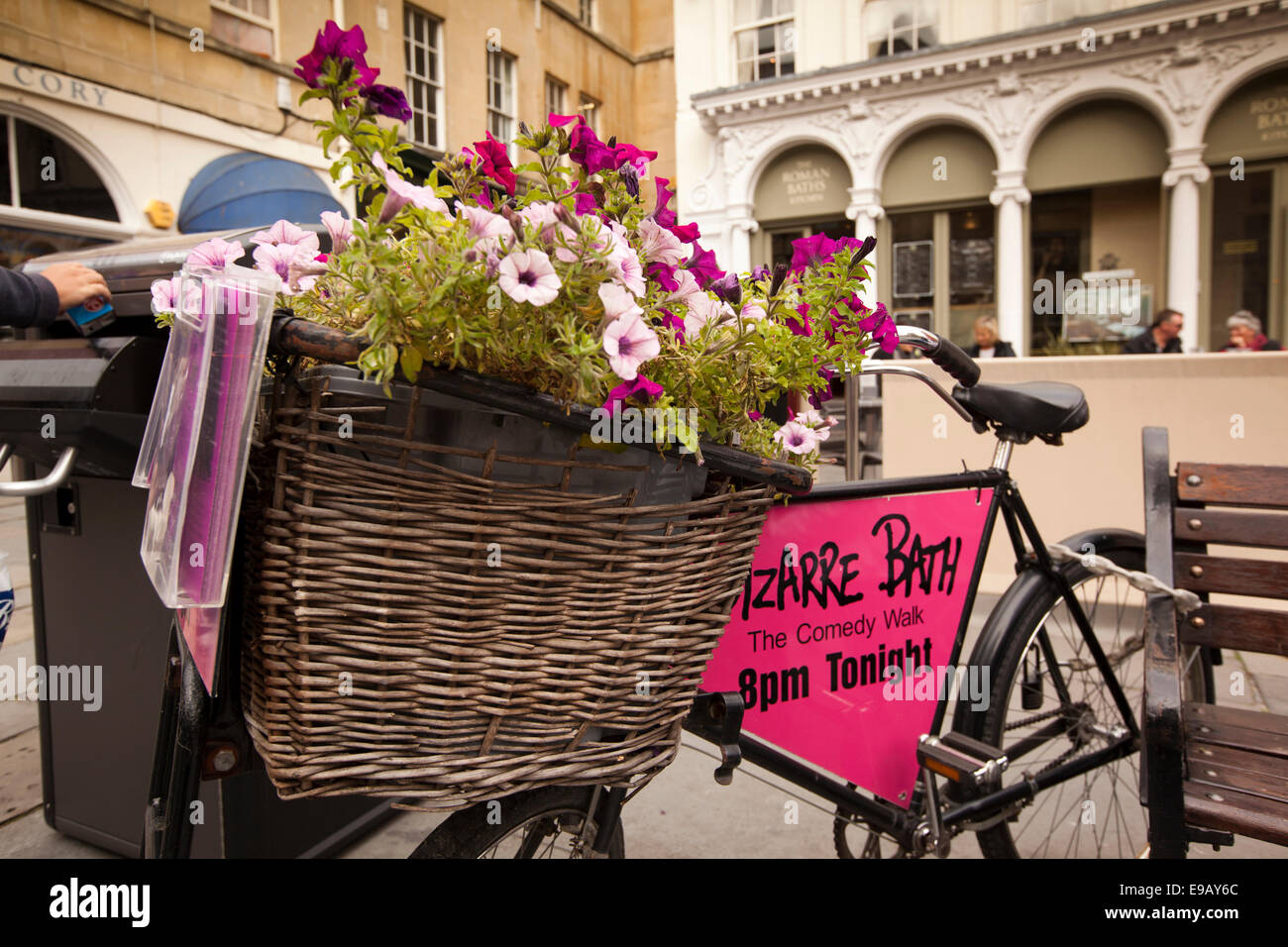 UK, England, Wiltshire, Bath, Abbey Churchyard, florally planted butcher’s bike basket advertising in Comedy Walk Stock Photo