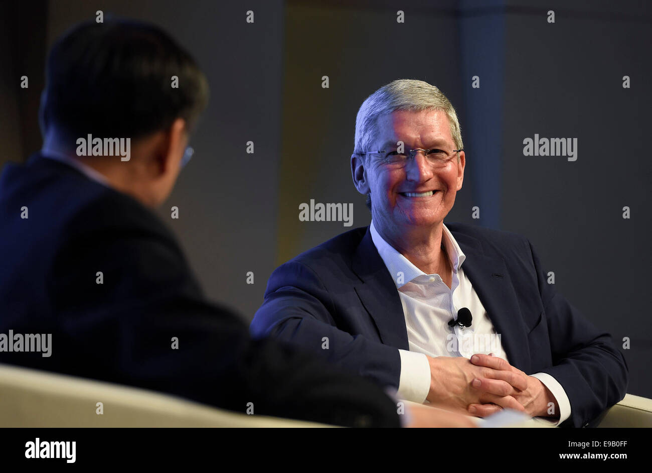 Beijing, China. 23rd Oct, 2014. Apple CEO Tim Cook reacts during a dialogue with Qian Yingyi, dean of Tsinghua University School of Economics and Management (SEM) during an exchange activity in Tsinghua, Beijing, China, Oct. 23, 2014. Credit:  Qi Heng/Xinhua/Alamy Live News Stock Photo