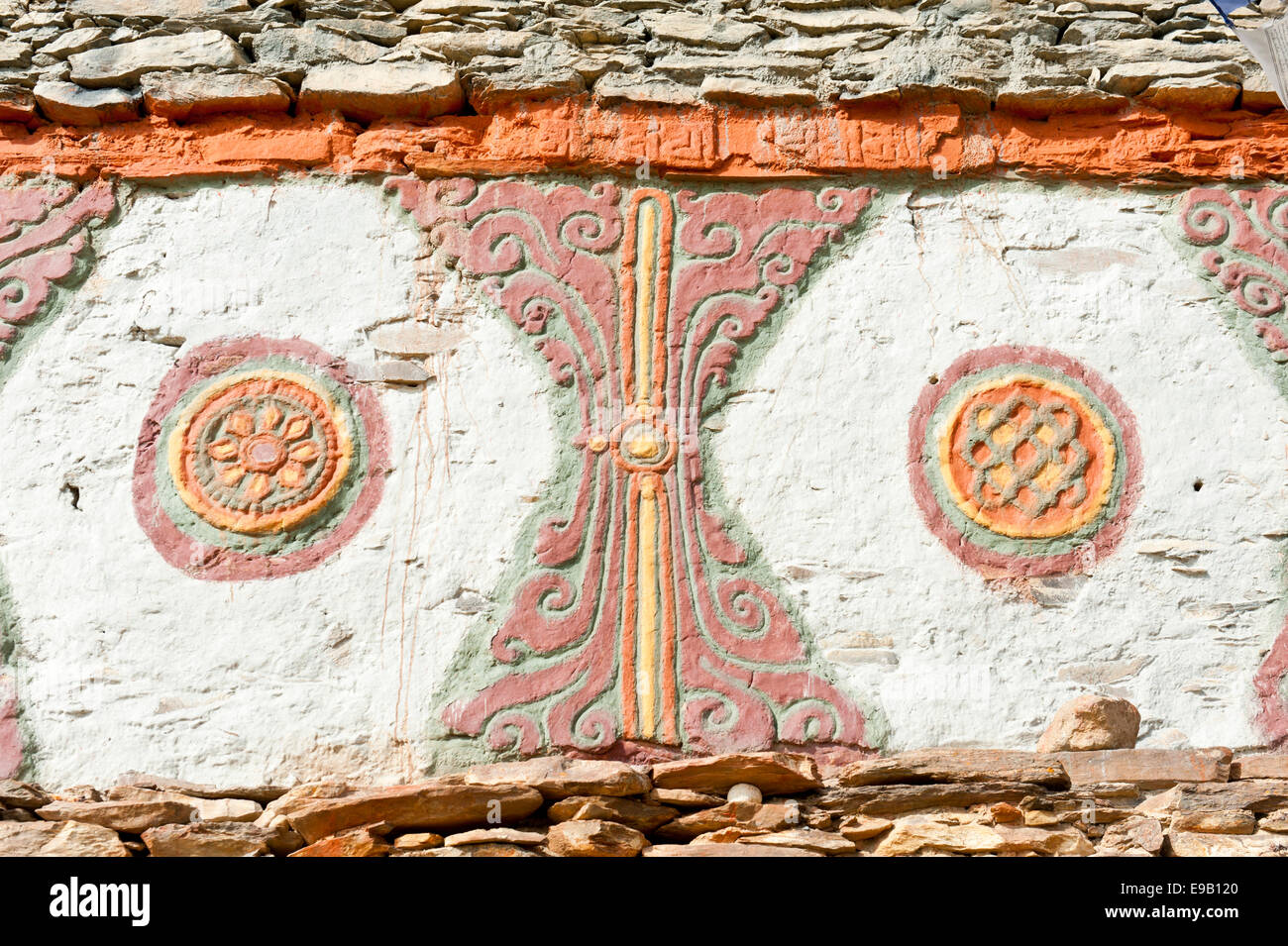 Colorfully decorated Buddhist Stupa, detail of two lucky symbols, the wheel of life and endless knot Stock Photo