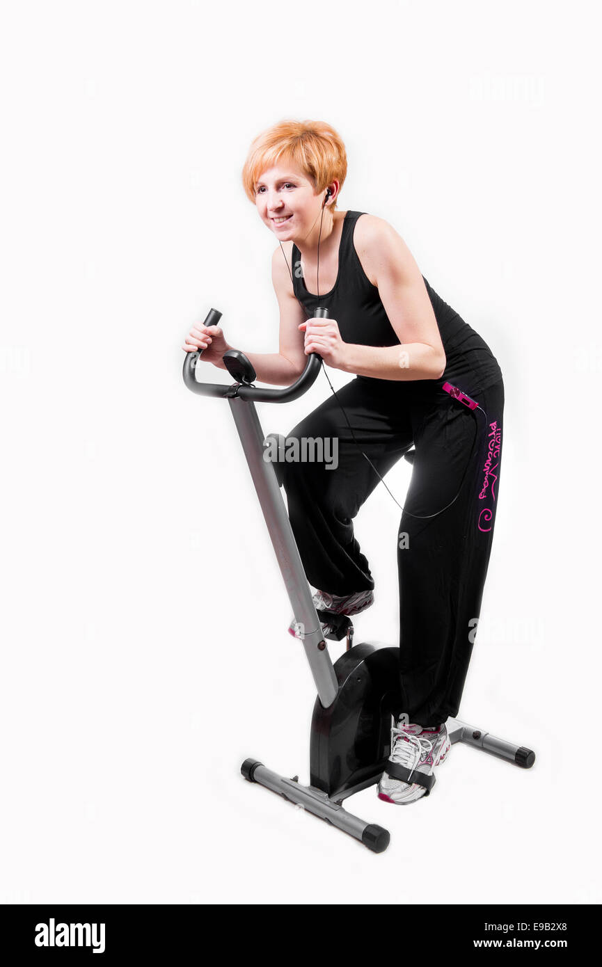 Woman doing sports on exercise bike Stock Photo