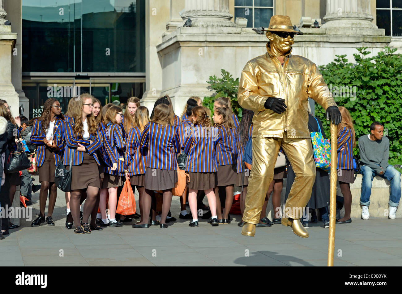 London, England, UK. 'Floating' human statue and a group of schoolgirls