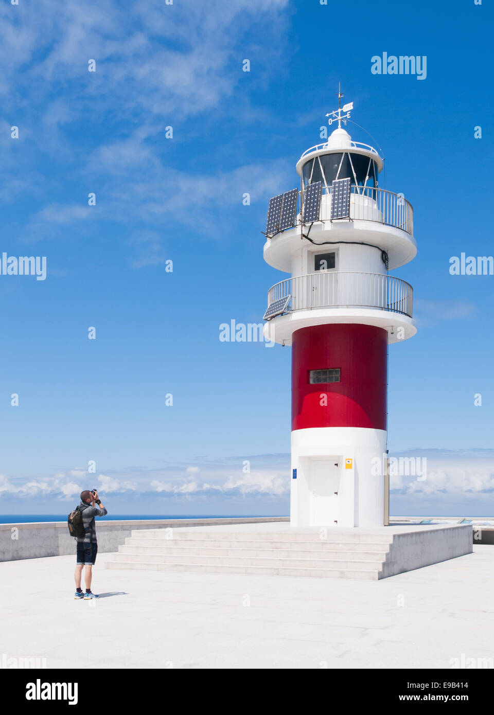 A man taking a picture to the lighthouse of Cabo Ortegal in Galicia, Spain. Stock Photo