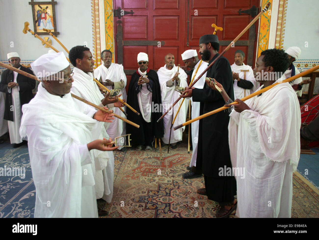 Priests with sticks sing during a vigil in the orthodox rite in the catholic Cathedral of the Holy Saviour, Adigrat, Ethiopia Stock Photo
