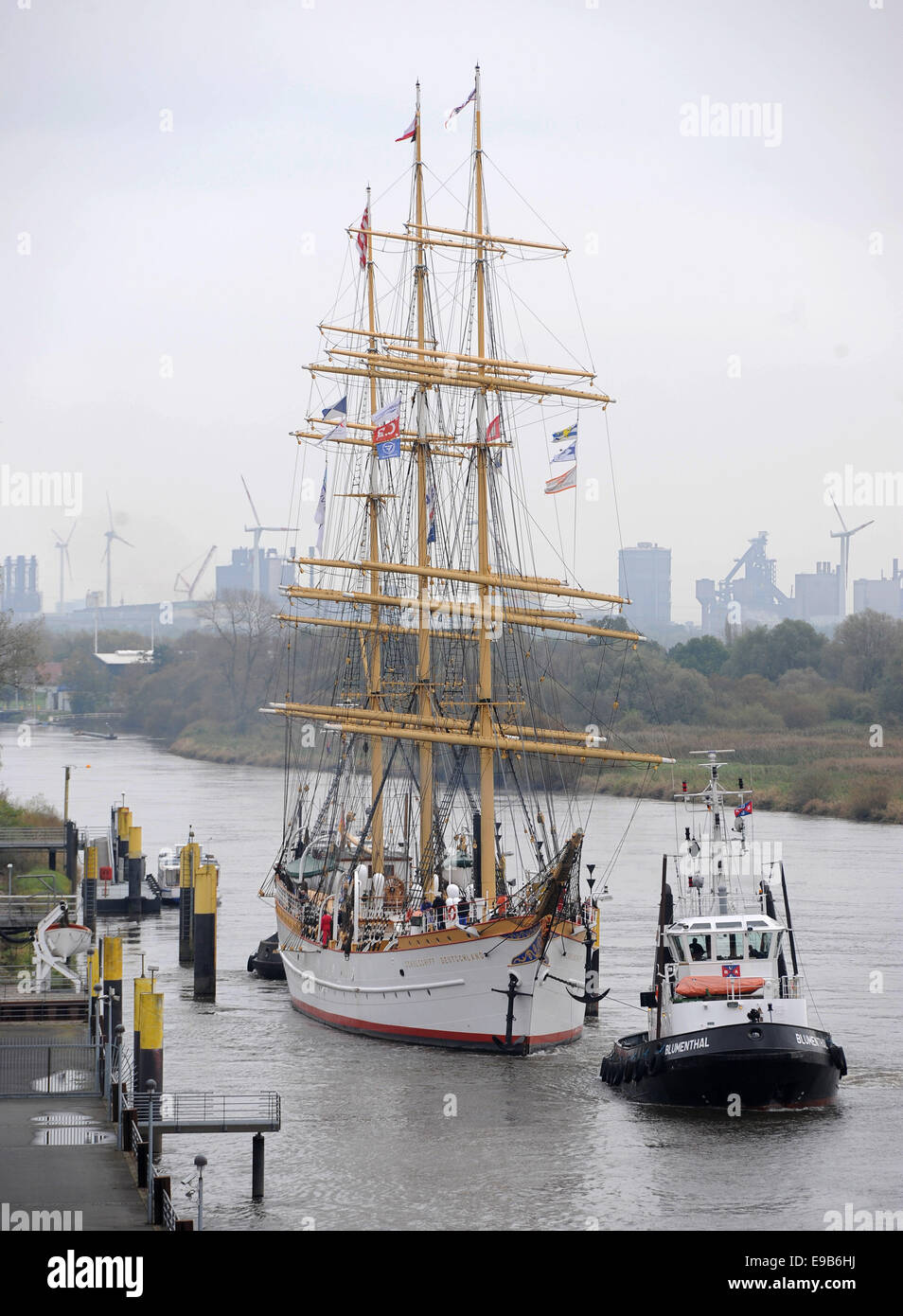 Bremen, Germany. 23rd Oct, 2014. The white tall ship 'Schulschiff Deutschland' (lit. school ship Germany) leaves its berth in Bremen, Germany, 23 October 2014. The last existing German full-rigged ship is taken to a wharf in Bremerhaven for repair works. The hull of the 87 year old ship has been damaged by rust. The repair works will cost about one million Euro. Photo: Ingo Wagner/dpa/Alamy Live News Stock Photo