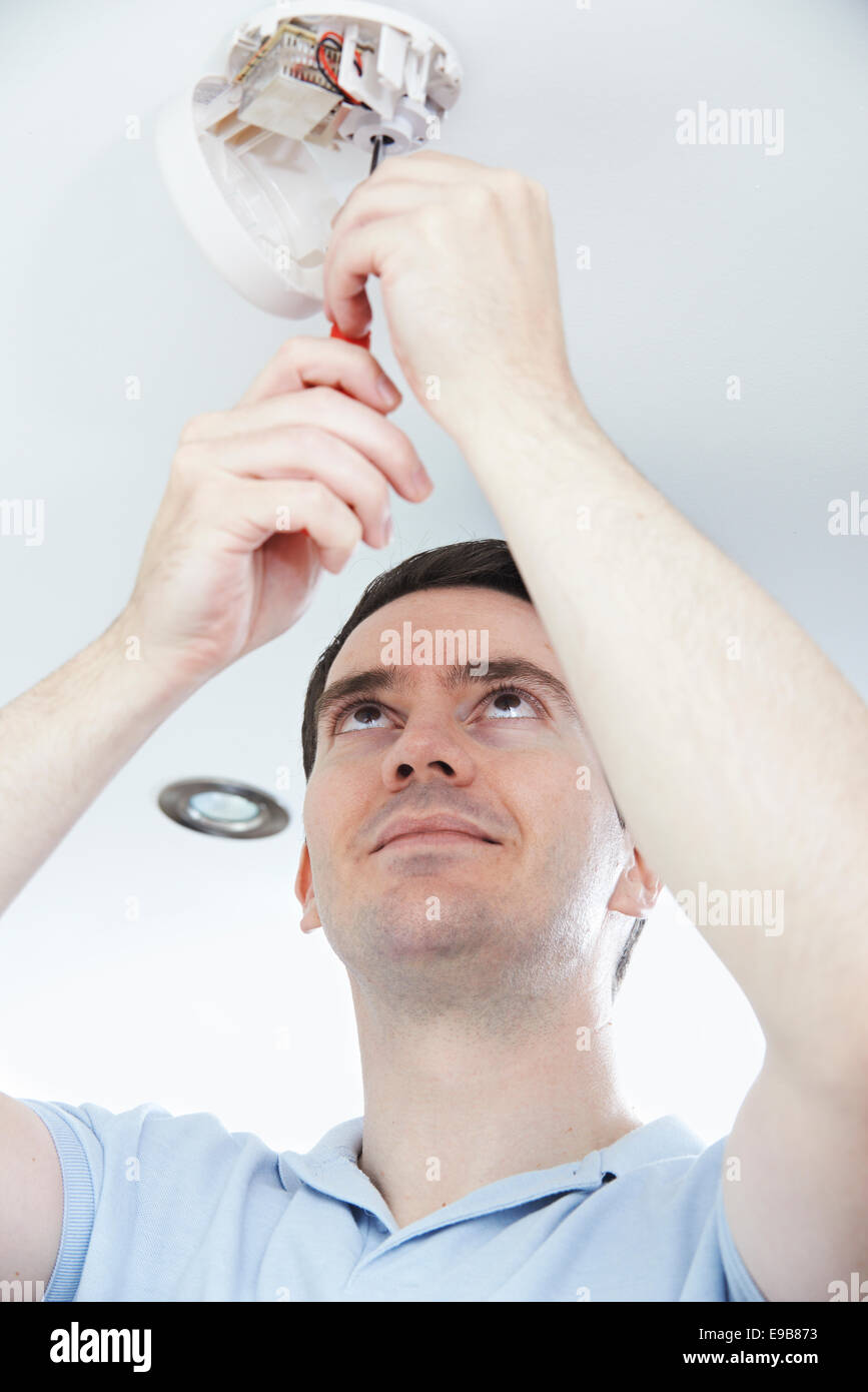 Man Installing Smoke Or Carbon Monoxide Detector Stock Photo