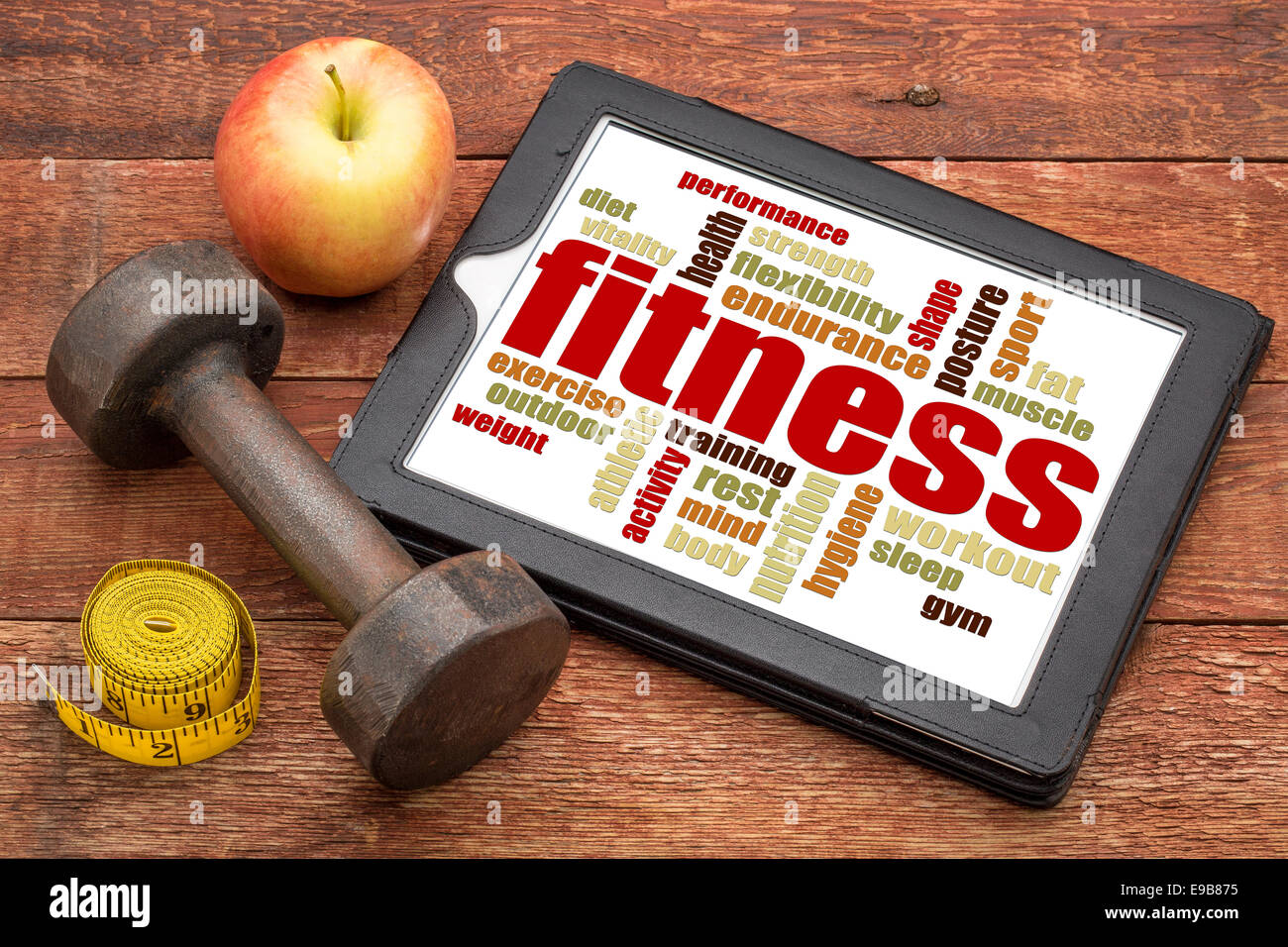 fitness word cloud on a digital tablet with a dumbbell, apple and tape measure Stock Photo