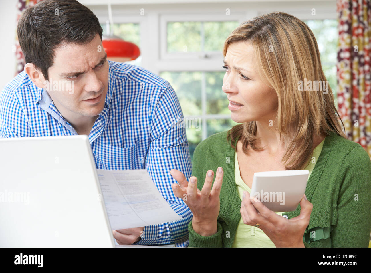 Worried Couple Discussing Domestic Finances At Home Stock Photo