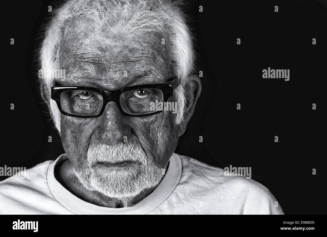 Black and white portrait of an elderly sad man with a tear rolling down his cheek Stock Photo