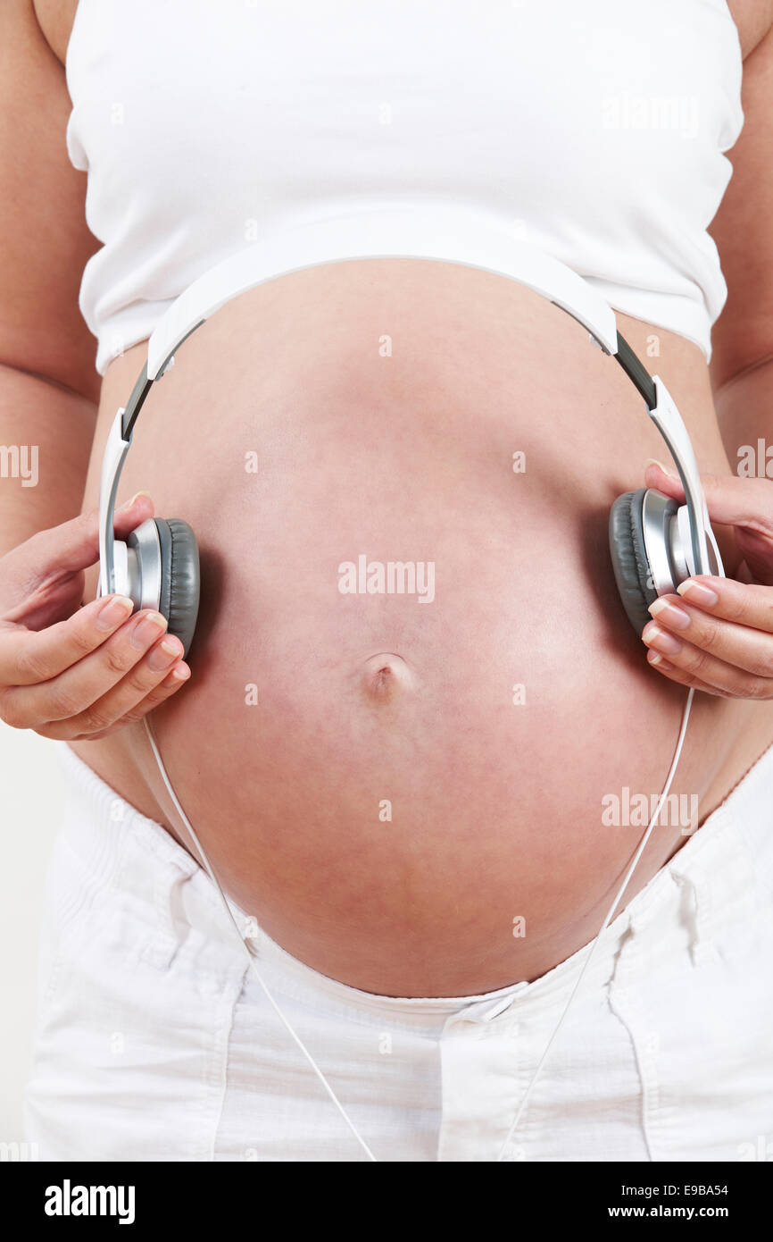 Hands of young pregnant woman put headphones with classical music on her pregnant  belly. Concept of intellectual intrauterine development of the child Stock  Photo - Alamy