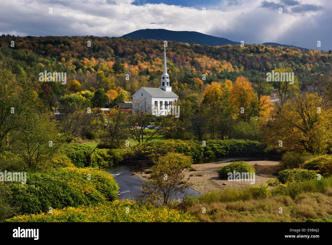 Waterbury river with Stowe Community Church against Fall color on Brush Hill in Vermont USA Stock Photo