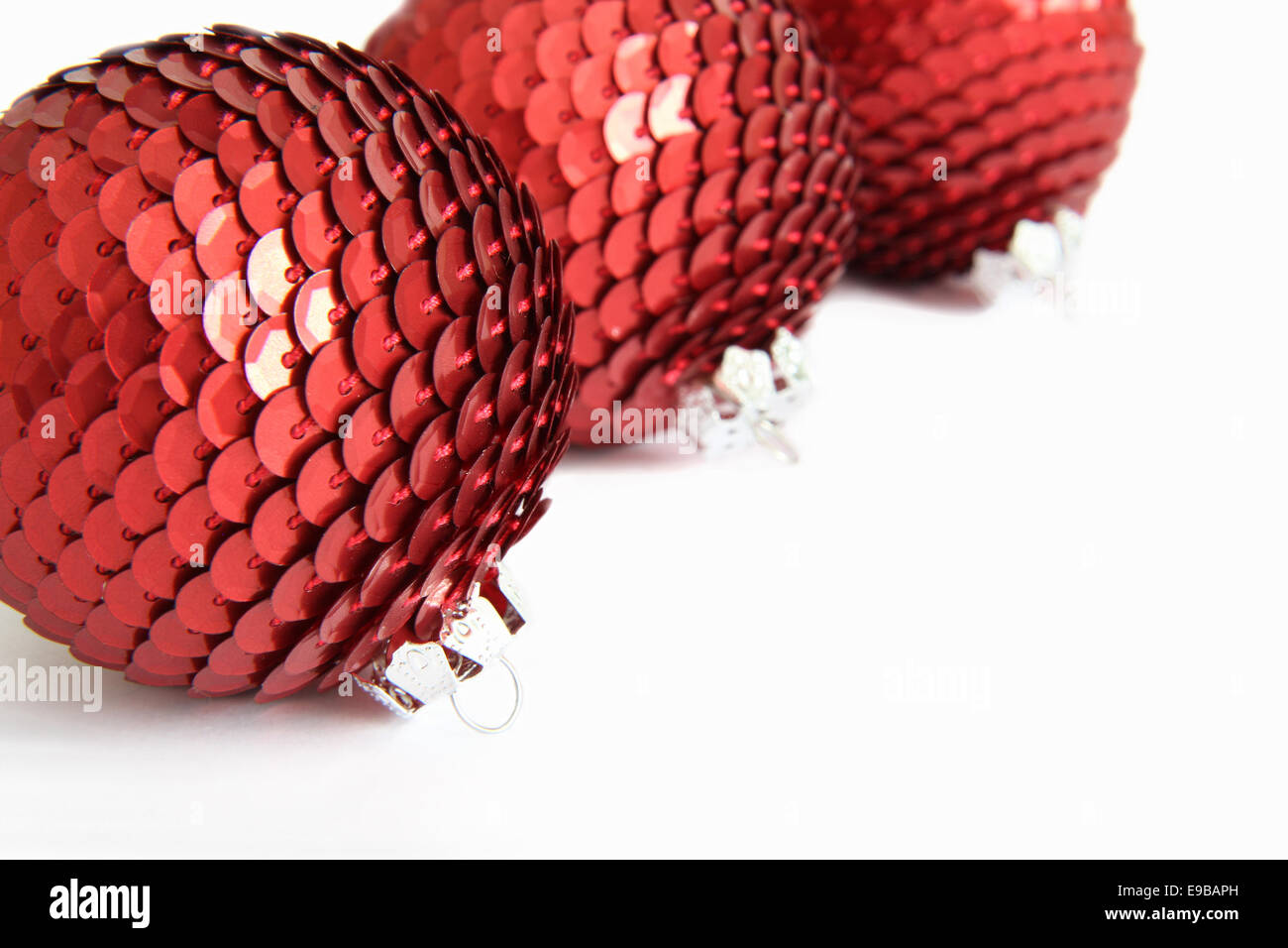 Three red Christmas sequin baubles on white. Stock Photo